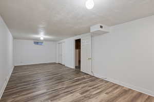 Finished below grade area with a textured ceiling and wood finished floors