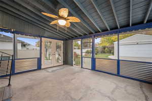 Unfurnished sunroom with french doors, ceiling fan, vaulted ceiling, and healthy amount of natural light
