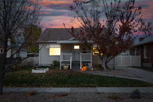 Bungalow featuring a porch, a gate, and roof with shingles