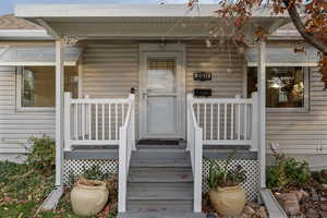 View of exterior entry featuring covered porch