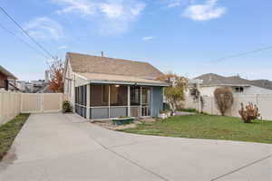 Back of house with a sunroom, a fenced backyard, and a shingled roof