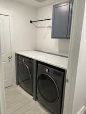 Laundry room featuring washing machine and clothes dryer and cabinet space