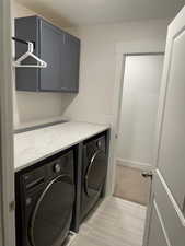 Washroom featuring independent washer and dryer and cabinet space