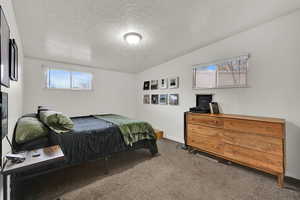 Carpeted bedroom featuring a textured ceiling and baseboards