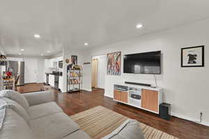 Living room with dark wood-style flooring and recessed lighting