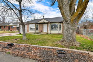 View of front of property featuring brick siding and roof with shingles