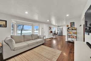 Living area featuring dark wood-style flooring and recessed lighting