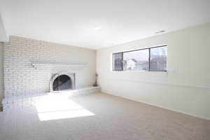 Unfurnished living room with a fireplace and carpet floors