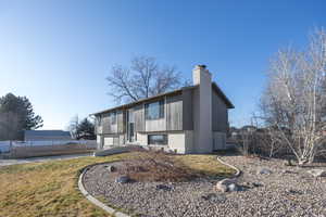 Split foyer home with a chimney, a garage, and brick siding