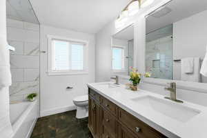 Full guest bathroom featuring double vanity with quartz counter and custom tile surround