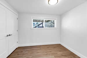Guest bedroom with light wood-style floors and a closet