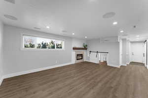 Basement living room with a barn door leading into play room, electric fireplace