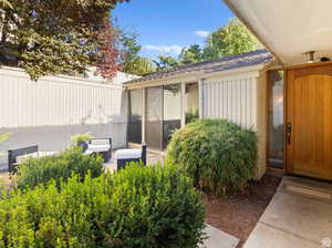 View of exterior entry featuring board and batten siding and a sunroom