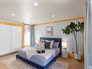 Carpeted bedroom featuring recessed lighting and wood walls