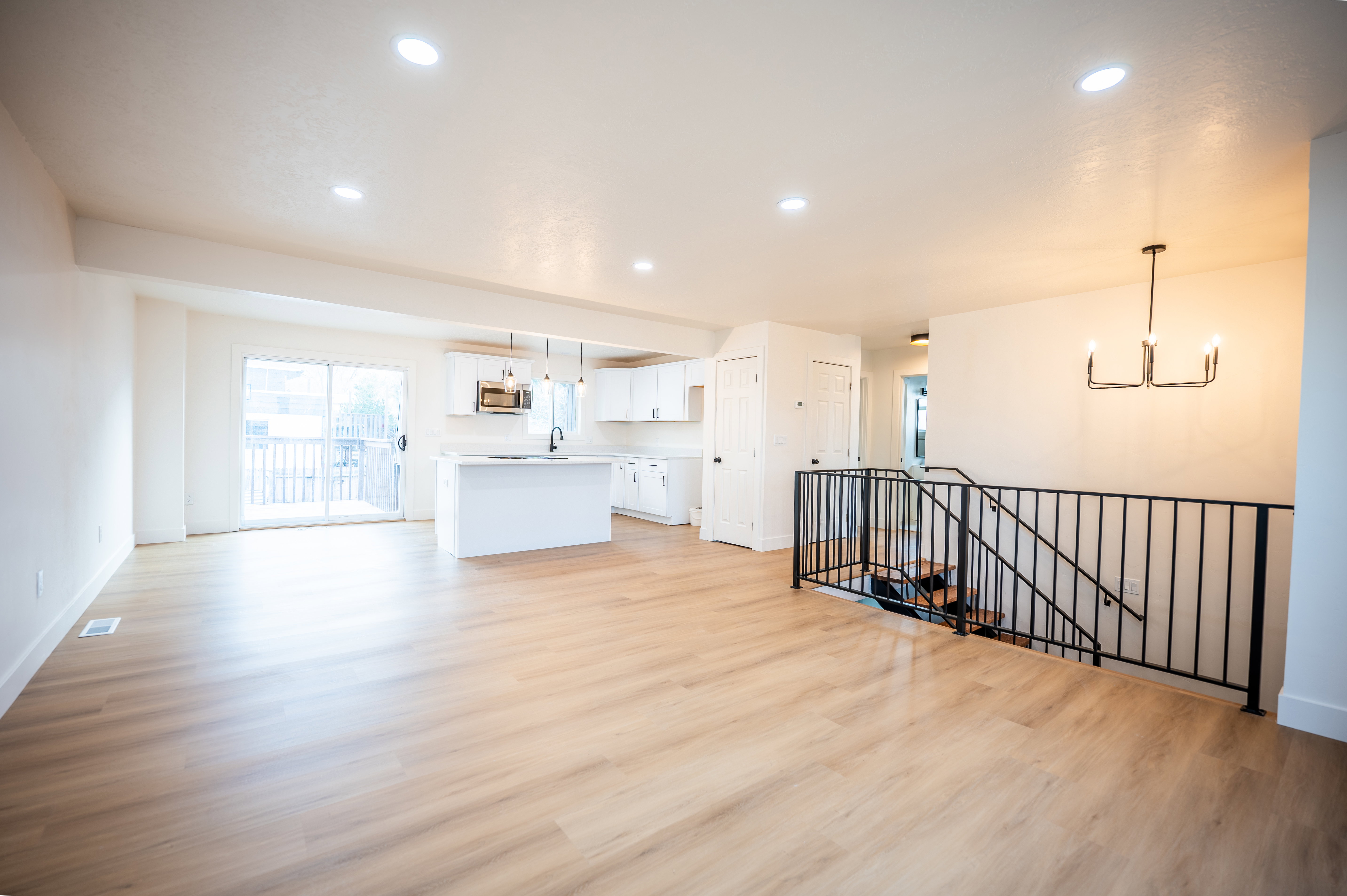Unfurnished living room featuring light wood-type flooring, recessed lighting, and a chandelier