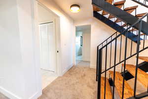 Stairs featuring carpet and tile patterned flooring