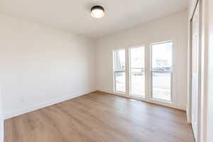 Empty room with light wood-type flooring and baseboards