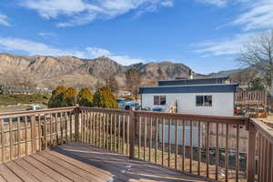 Wooden deck with a mountain view and a fenced backyard