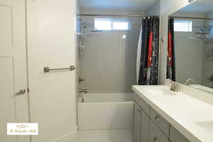 Primary Full bathroom featuring double vanity and shower / tub combo with curtain