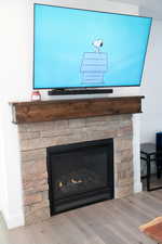 Detailed view of a stone fireplace and wood laminate floors