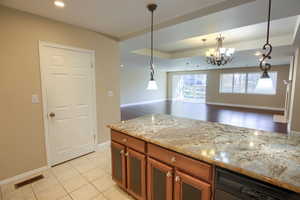 Kitchen featuring brown cabinetry, pendant lighting, black dishwasher, open floor plan, and recessed lighting