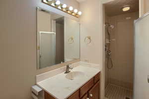 Full bathroom featuring vanity and a shower stall