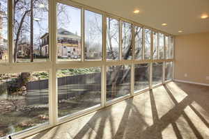 Unfurnished sunroom with carpet and recessed lighting