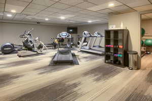 5th floor- Exercise room featuring a paneled ceiling and recessed lighting