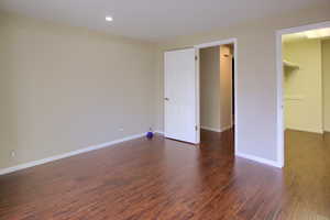 Unfurnished bedroom with dark wood-type flooring and recessed lighting