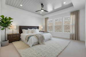 Enhanced staged photo, Bedroom featuring light colored carpet, a wooden tray ceiling, a ceiling fan, and recessed lighting