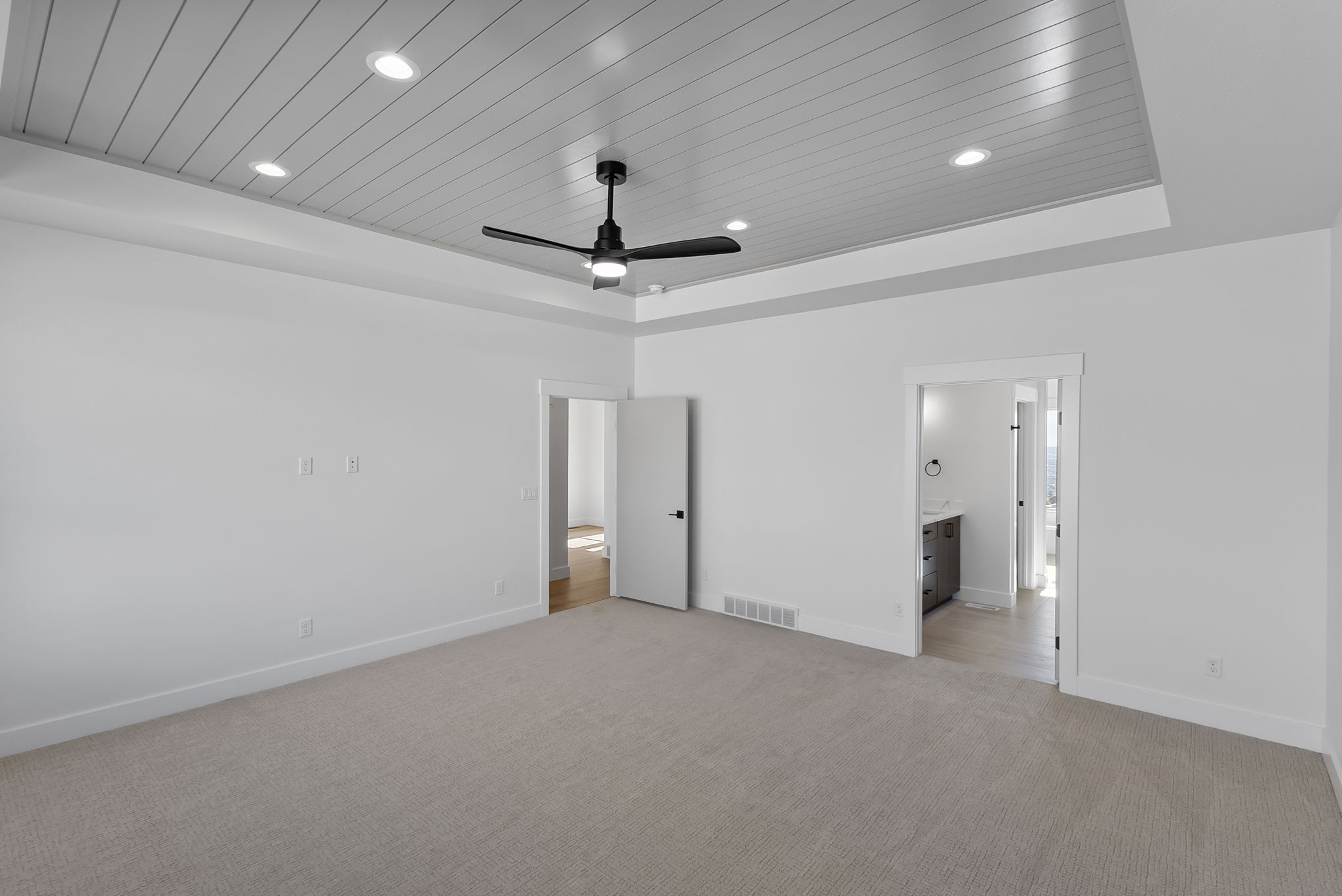 Unfurnished bedroom with wooden ceiling, light colored carpet, a ceiling fan, a raised ceiling, and recessed lighting