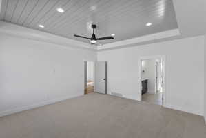 Spacious room featuring a tray ceiling with shiplap detailing, recessed lighting, a ceiling fan, and light-toned carpeting