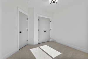 Unfurnished bedroom featuring a closet and light colored carpet