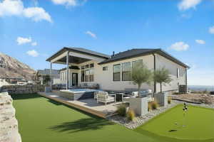 Enhanced photo (Landscape not included) Back of property featuring an outdoor living space, a putting green, a patio area, and a deck with mountain view