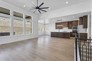 Unfurnished living room featuring ceiling fan, light wood-style floors, and recessed lighting