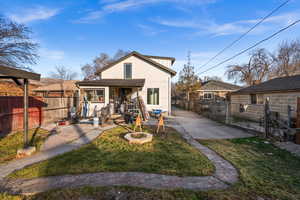 Back of property featuring stucco siding, a fenced backyard, a patio, and a gate