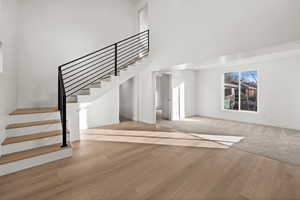 Staircase featuring a high ceiling and hardwood / wood-style flooring