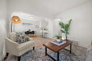 Living area with arched walkways and wood finished floors