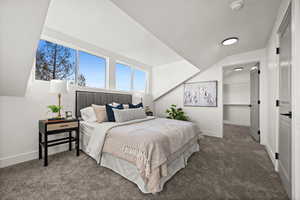 Bedroom with carpet floors and vaulted ceiling
