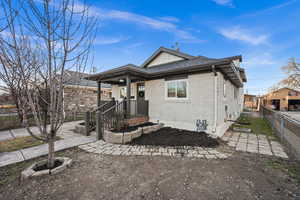 View of front of property featuring brick siding, roof with shingles, and board and batten siding