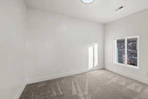 Carpeted spare room with baseboards