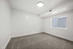 Carpeted spare room with baseboards