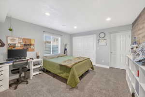 Bedroom featuring light colored carpet, a closet, an office area, and recessed lighting
