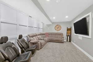 Living area with carpet floors, recessed lighting, and a decorative wall