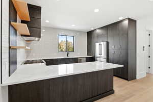 Kitchen featuring a peninsula, open shelves, modern cabinets, decorative backsplash, and light wood-type flooring