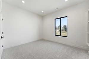 Carpeted empty room featuring recessed lighting and baseboards