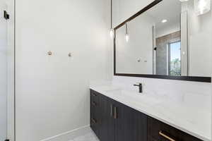 Bathroom with vanity, a shower with shower door, and light marble finish floors