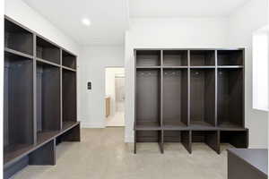 Mudroom featuring finished concrete flooring and baseboards