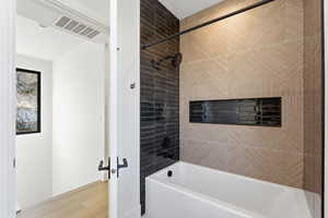 Full bathroom featuring shower / tub combination and wood finished floors