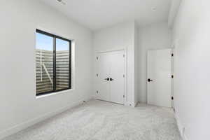 Unfurnished bedroom featuring light colored carpet and a closet